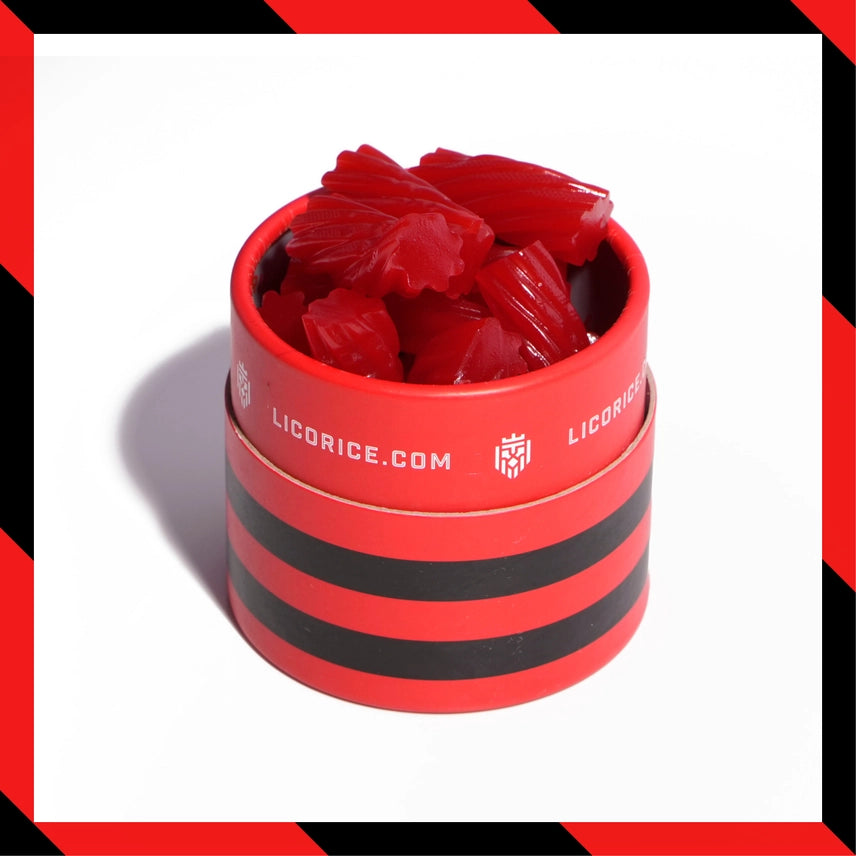 Red licorice pieces in a striped container with 'licorice.com' branding on a white background.