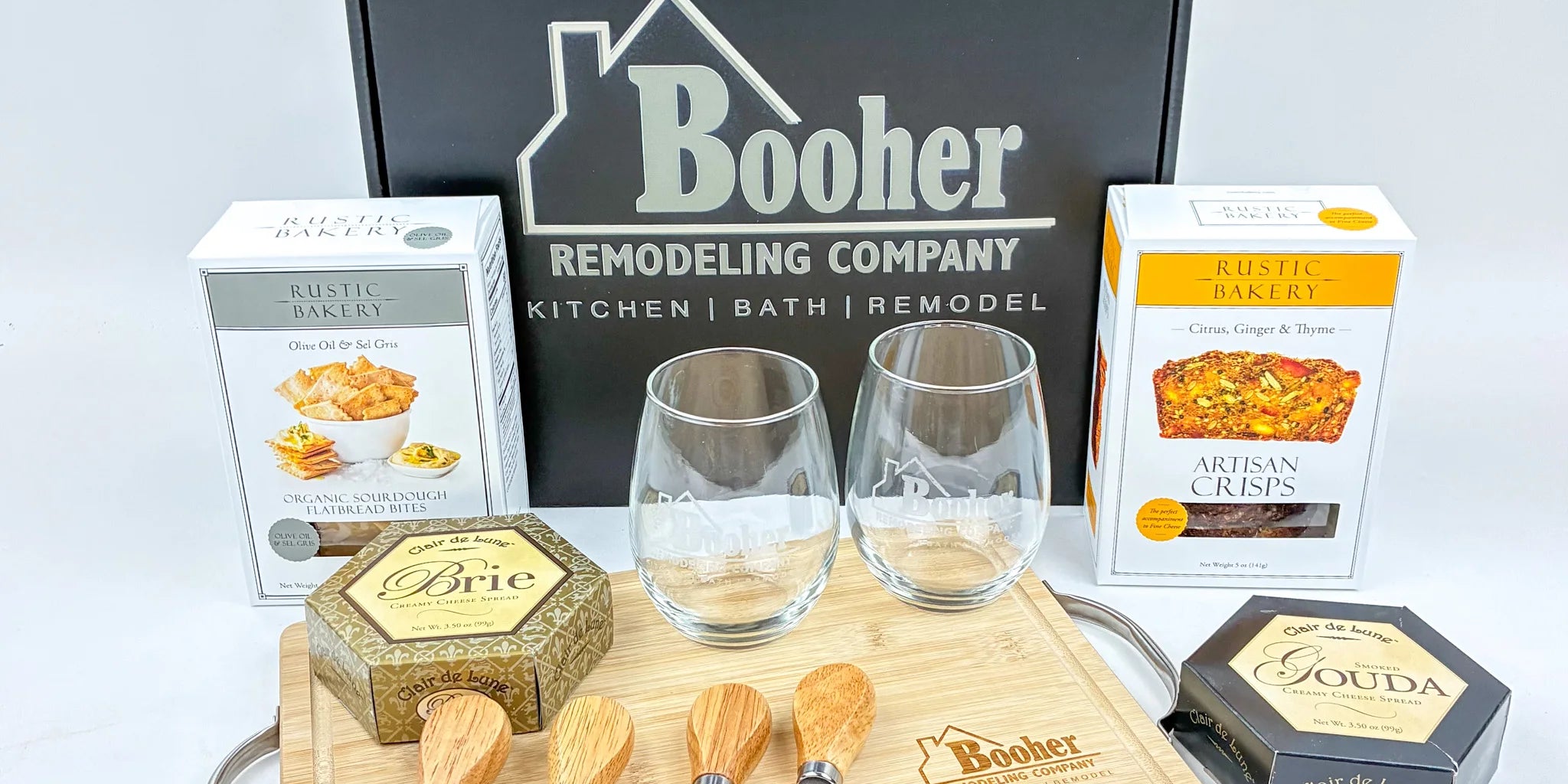 Cheeseboard set with glasses and snacks in front of a Booher Remodeling Company box.