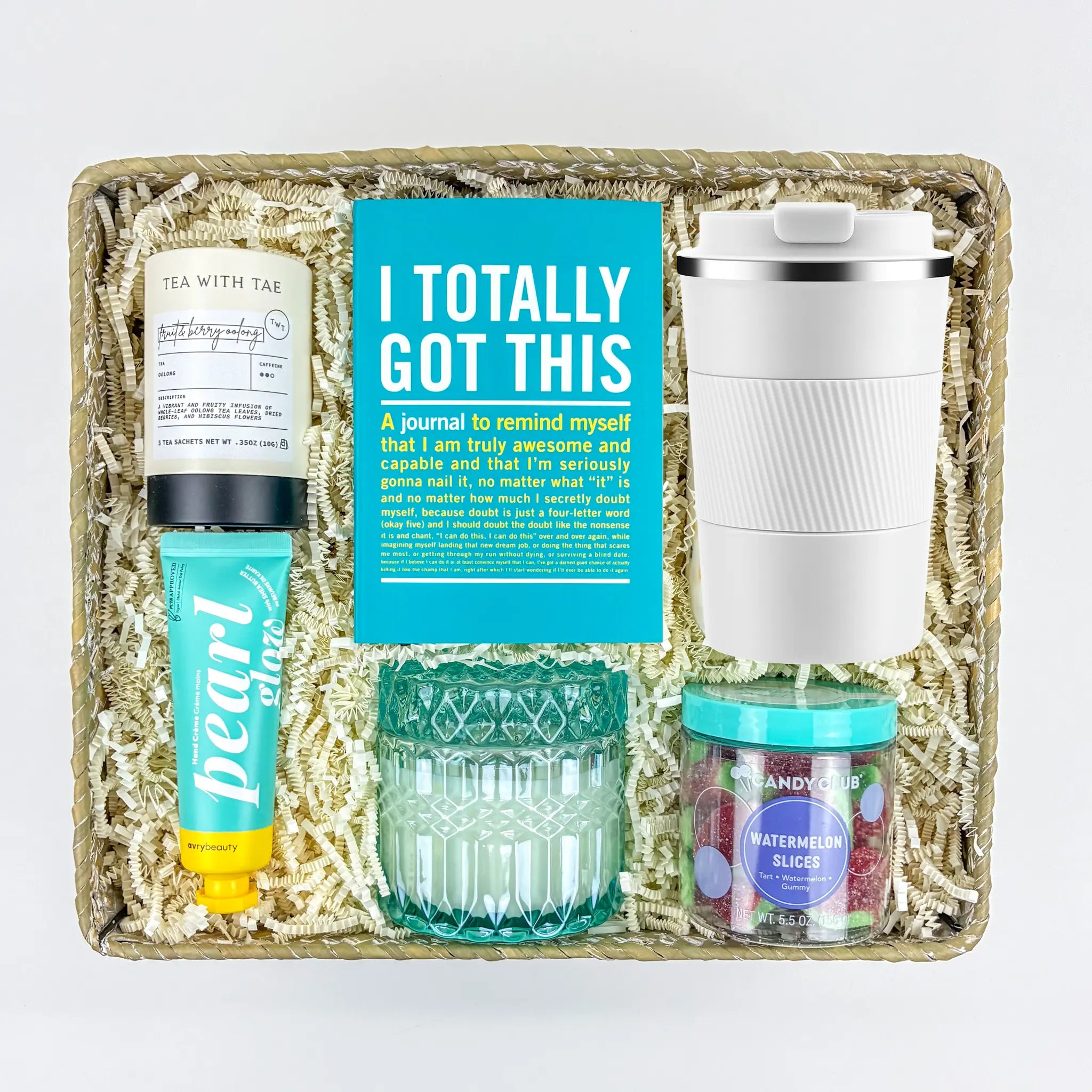 Gift set with a journal, tea, lip balm, glass, and other items in a decorative box.