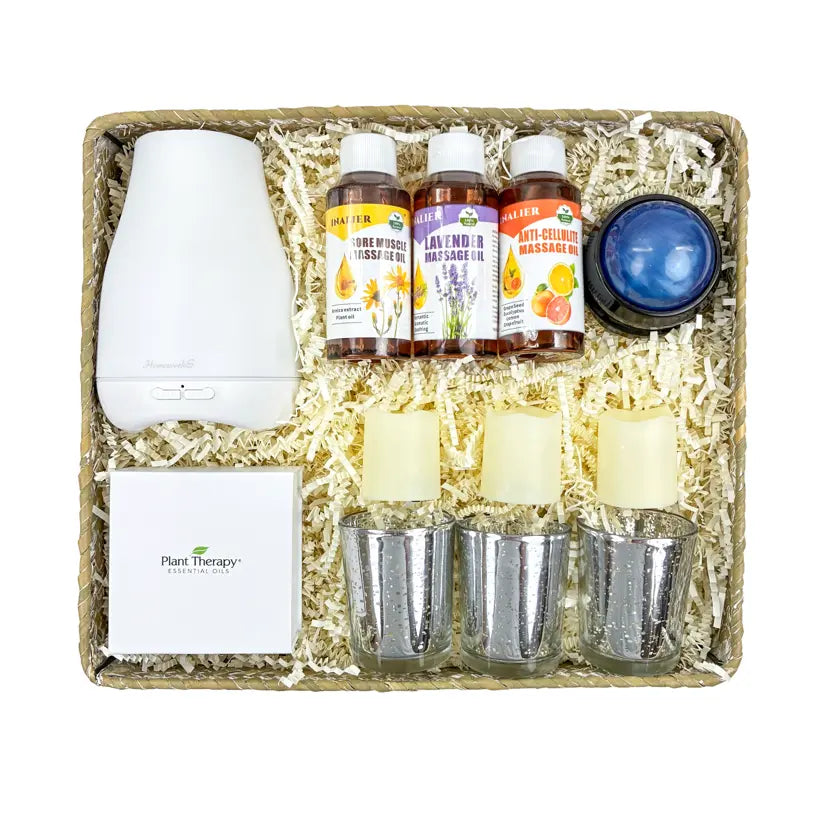 Massage gifting set with diffuser, candles, and essential oil bottles in a decorative box.