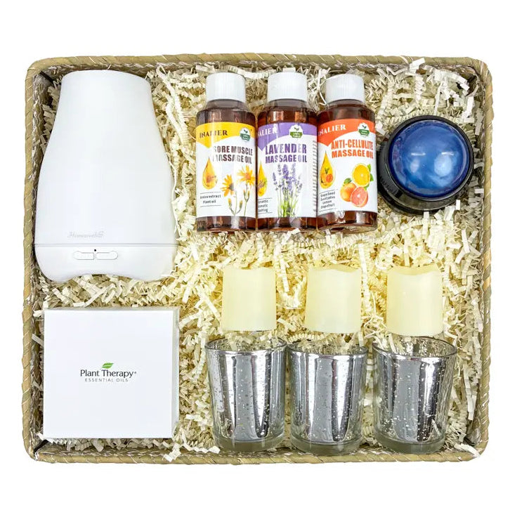 Massage gifting set with diffuser, candles, and essential oil bottles in a decorative box.