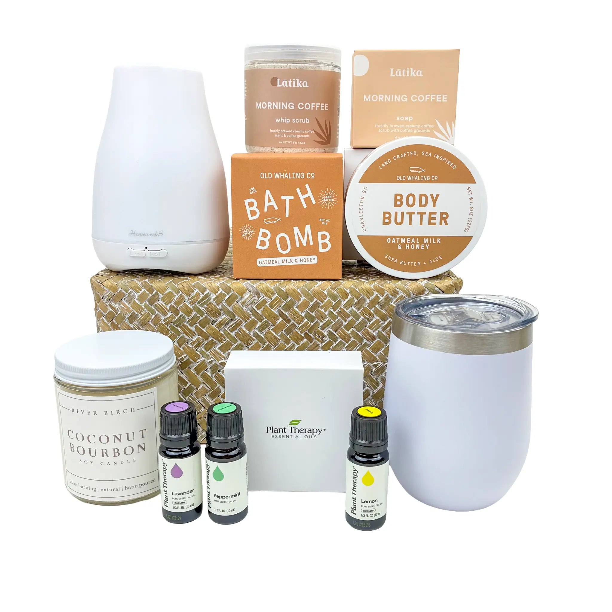 Collection of self-care products including a diffuser, candles, and essential oils on a white background.