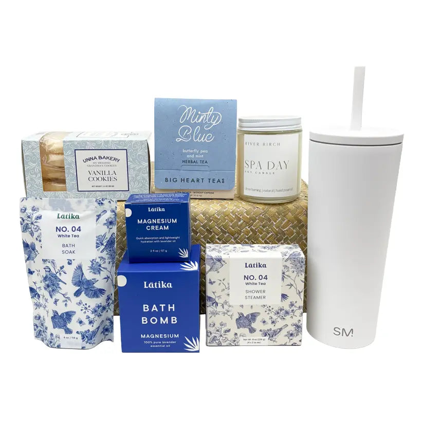 Collection of bath and body products including a tumbler, candles, and soaps on a white background.