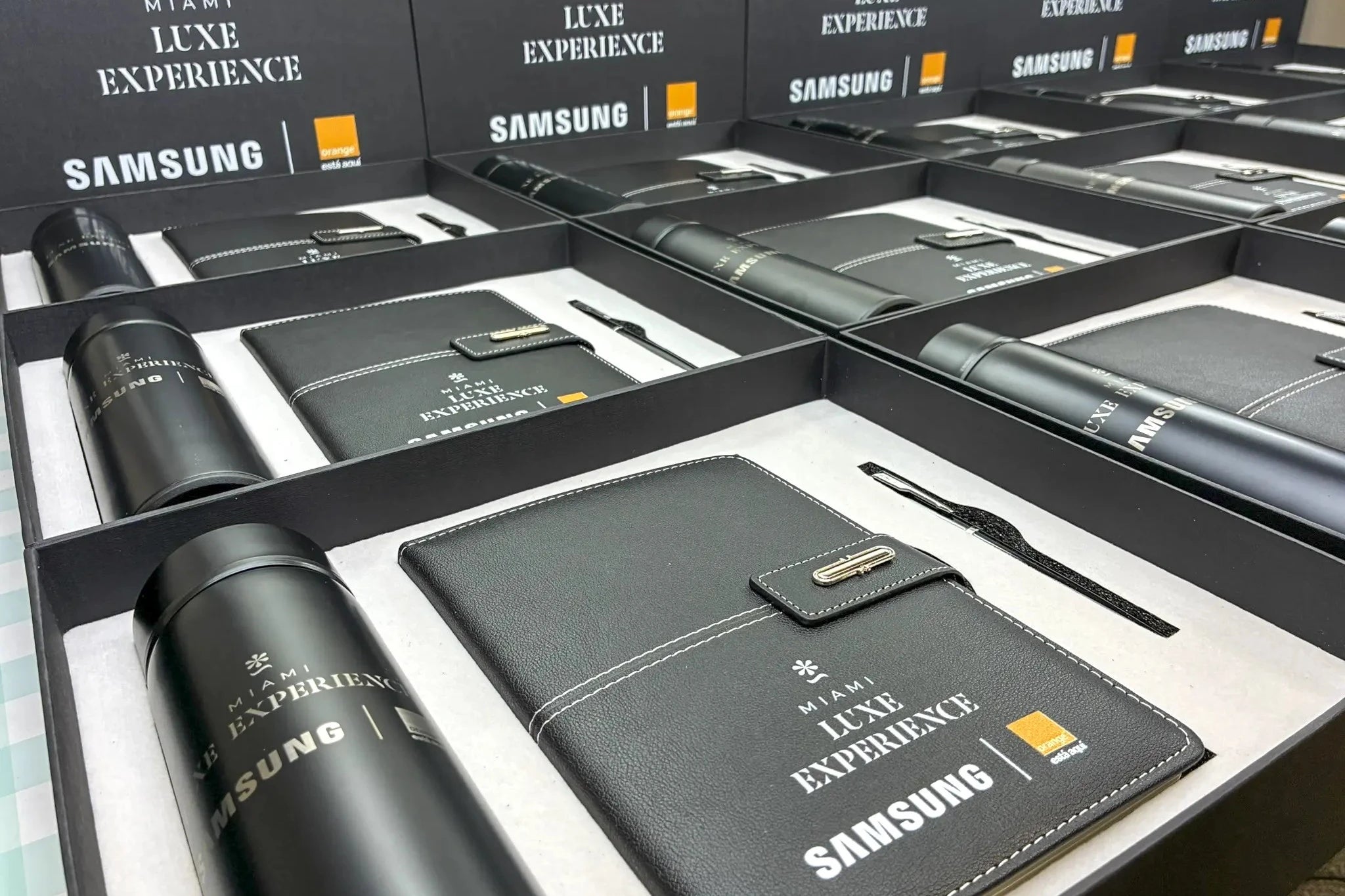 Samsung Luxe Experience product set including a water bottle, pen, and wallet in branded packaging.