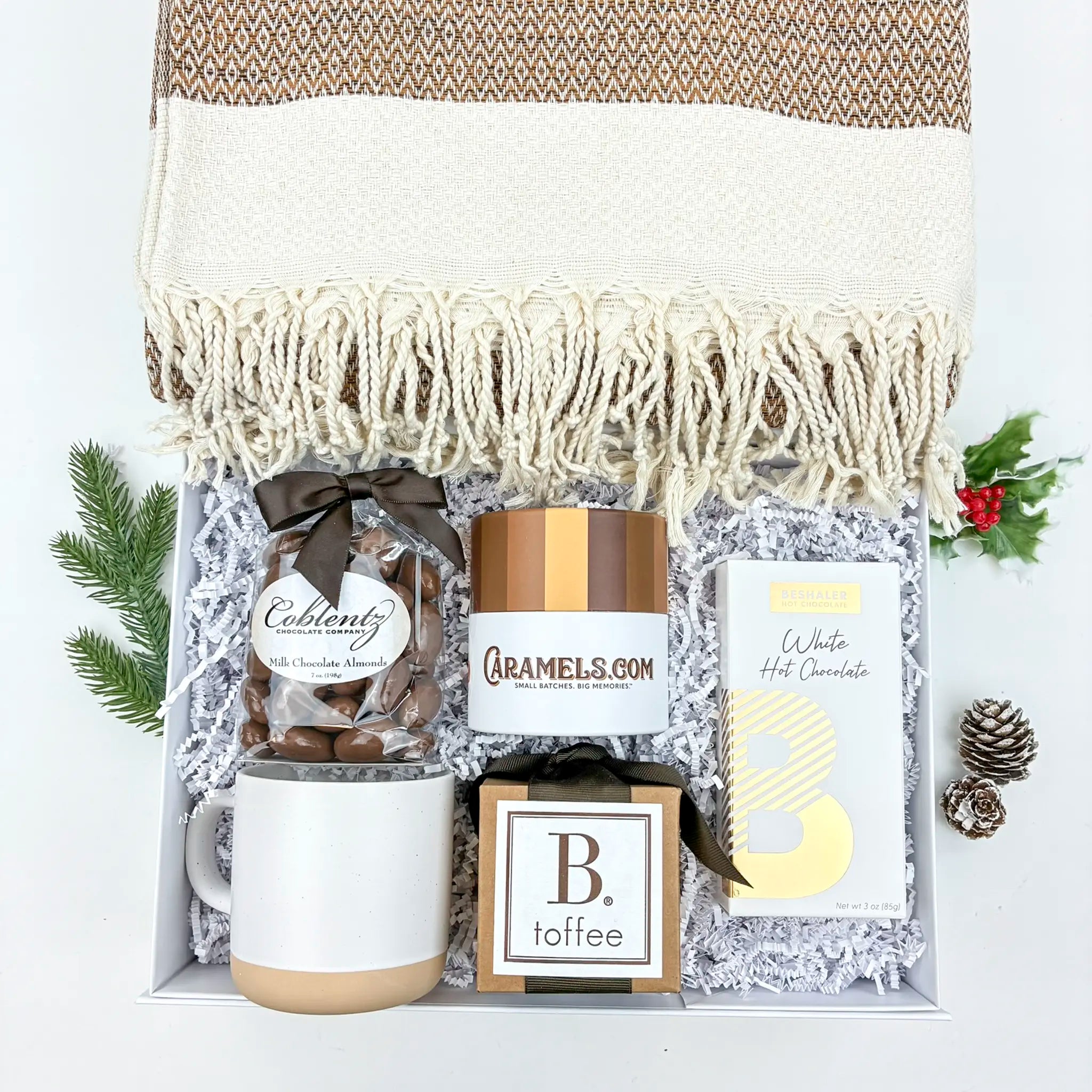 Gift basket with mug, chocolate, and hot chocolate mix on a white background