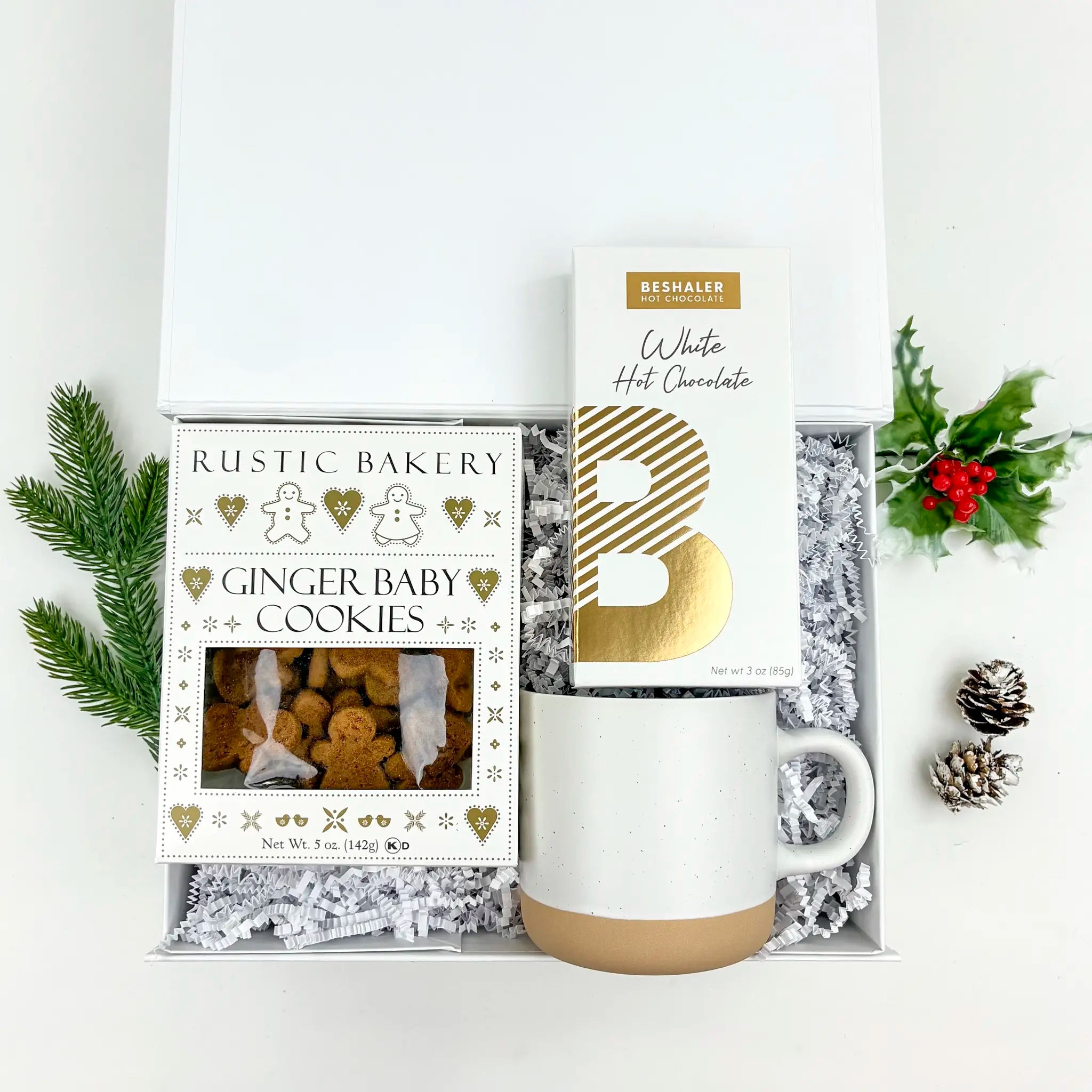 Gift set with mug, gingerbread cookies, and hot chocolate mix in a decorative box.