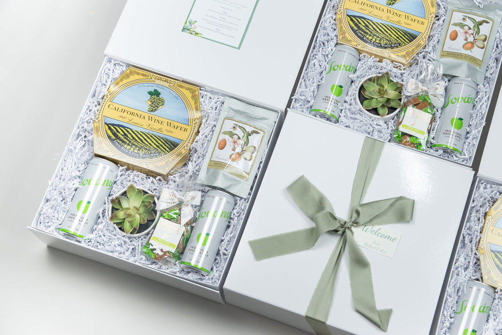 Corporate gift box with ribbon, containing gourmet snacks, a succulent and drinks, perfect for clients and employees.