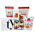 Assorted snack packages including Butter Toffee Pretzels and Daelmans Stroopwafels Minis on a white background.