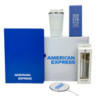 Collection of branded items including a blue notebook, white tumbler, and packaging with 'American Express' branding.