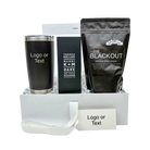 Gift set with black tumbler, chocolate bar, and coffee package in a box.