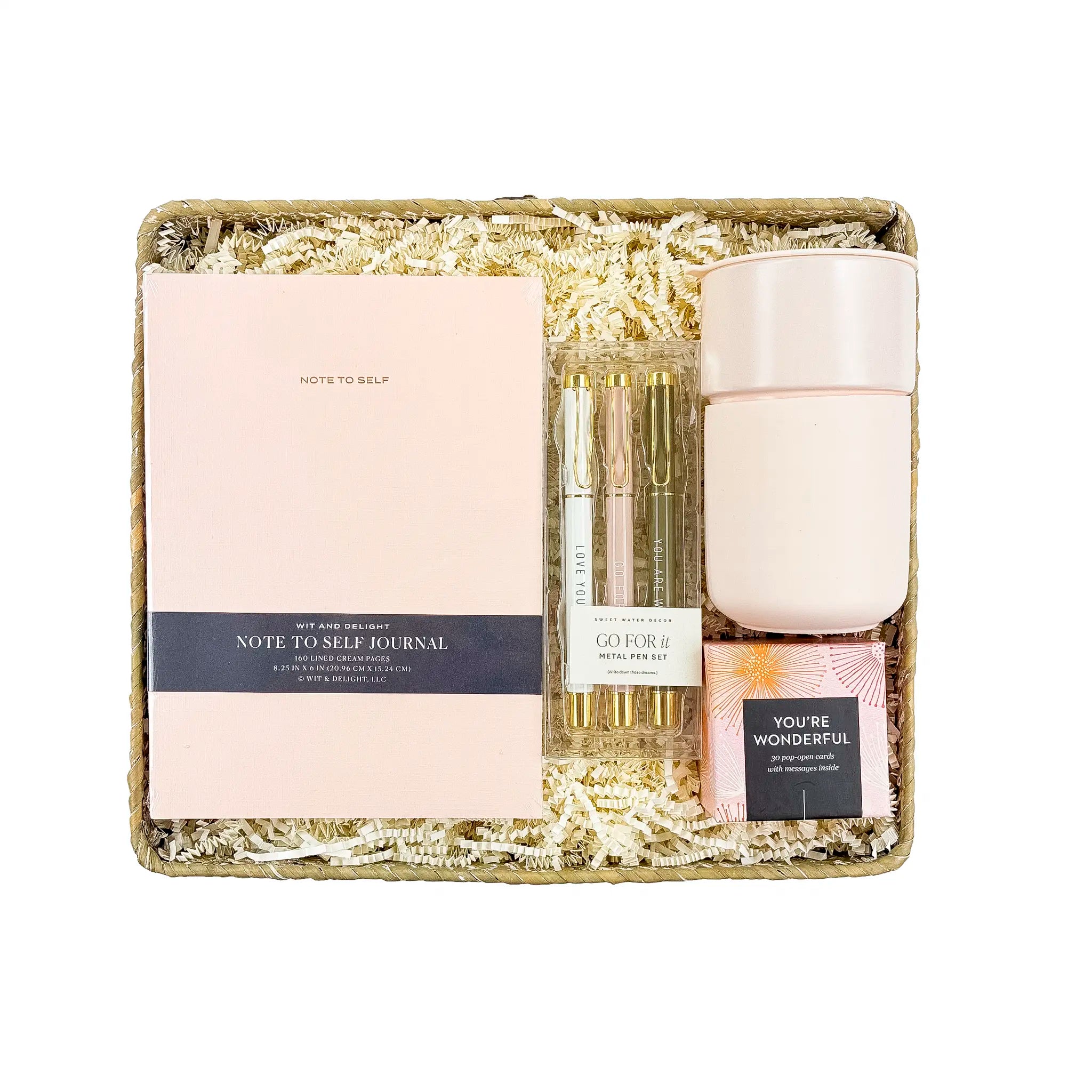 Gift set with a journal, candle, and small bottle on a white background