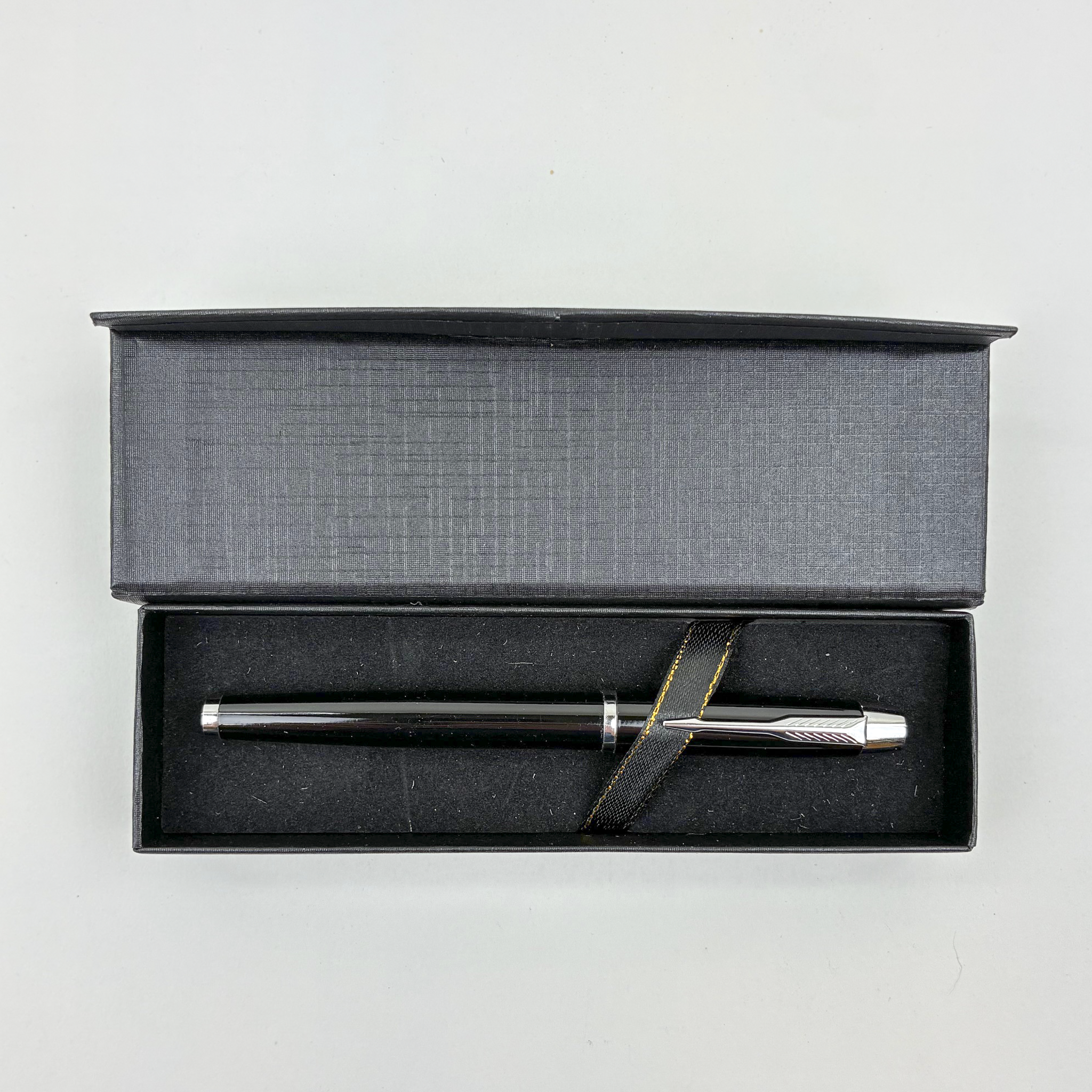 Silver pen in a black gift box on a light gray background