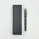 Black pen and its packaging on a white background
