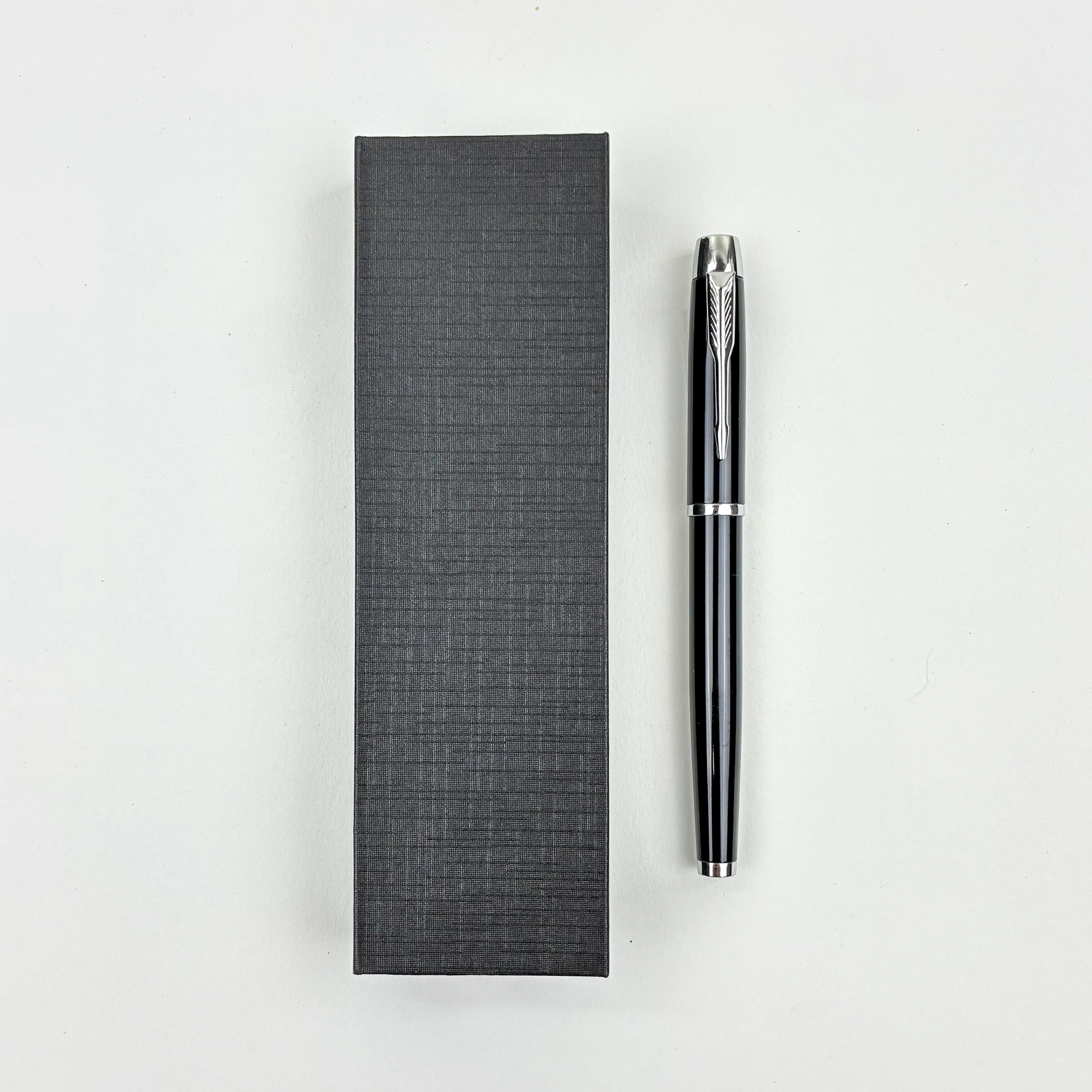 Black pen and its packaging on a white background