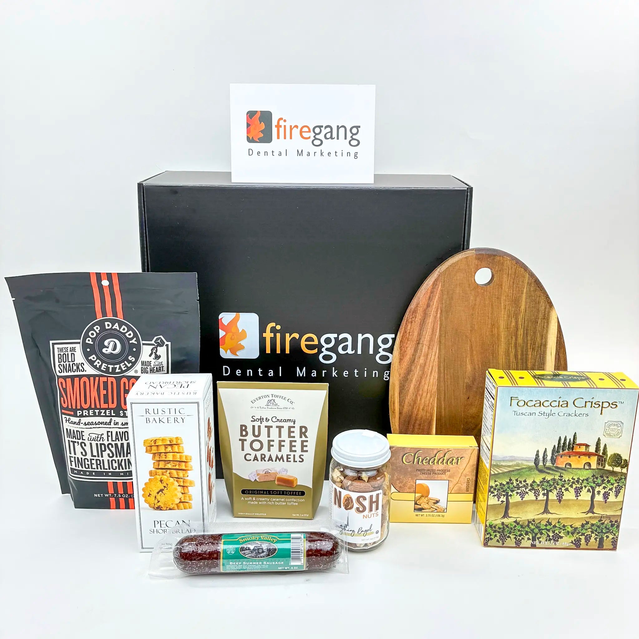 Assorted snacks and a cutting board with 'firegang Dental Marketing' branding on a white background.