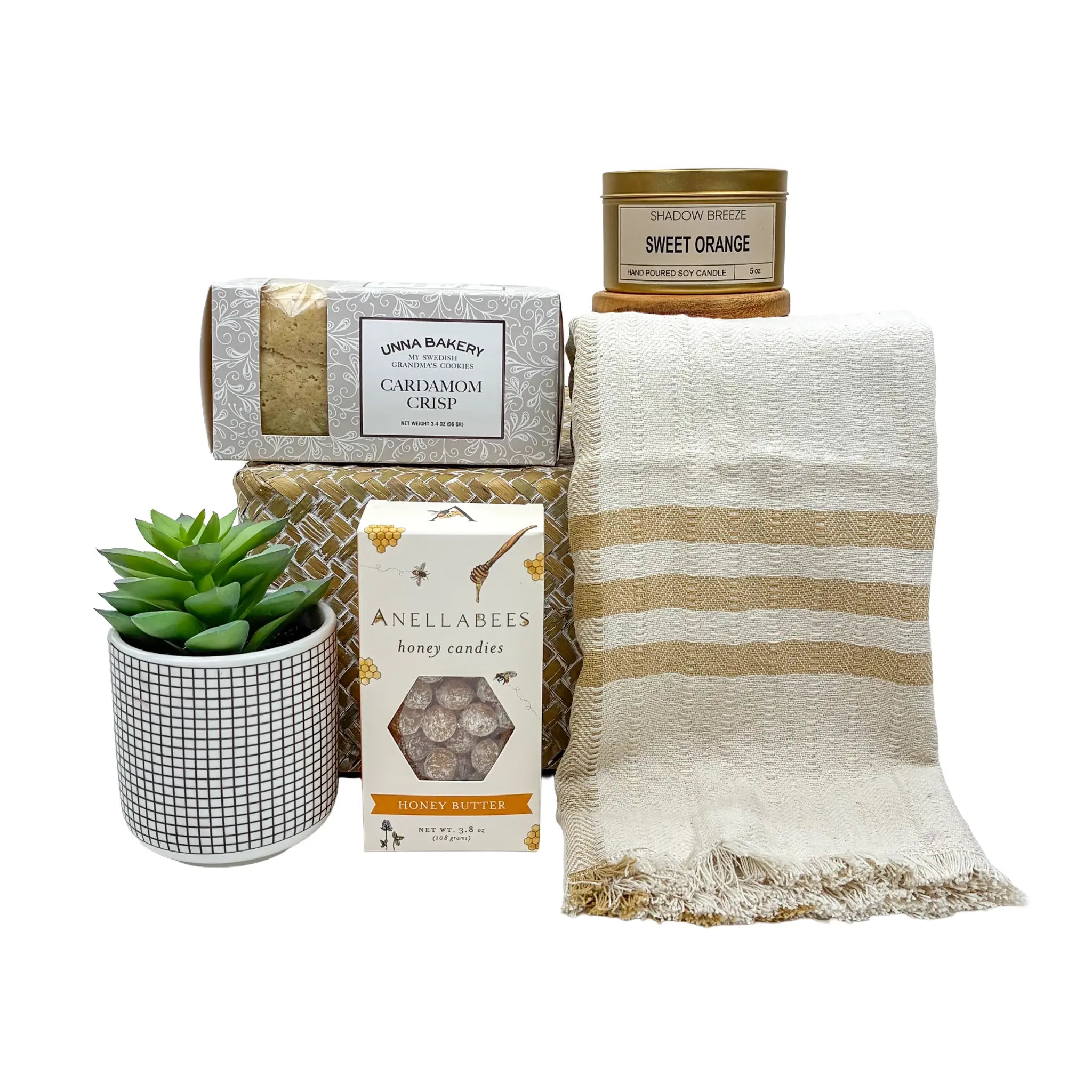Collection of home products including a plant, candles, and a blanket on a white background