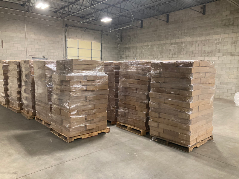 Stacks of pallets with wrapped items in a warehouse setting