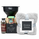 A curated gift basket set on a white background, featuring a black Mesh Country Popcorn funnel, a gray plush throw blanket with a white and gray 'Shadow Breeze' tag, a bottle of Mesh Country Blue Popcorn, a Vegtables snack jar, and a black 'Movie Night' scratch card box.