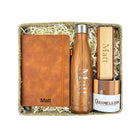 Gift set with brown leather notebook, wooden water bottle, and wooden item in a box.