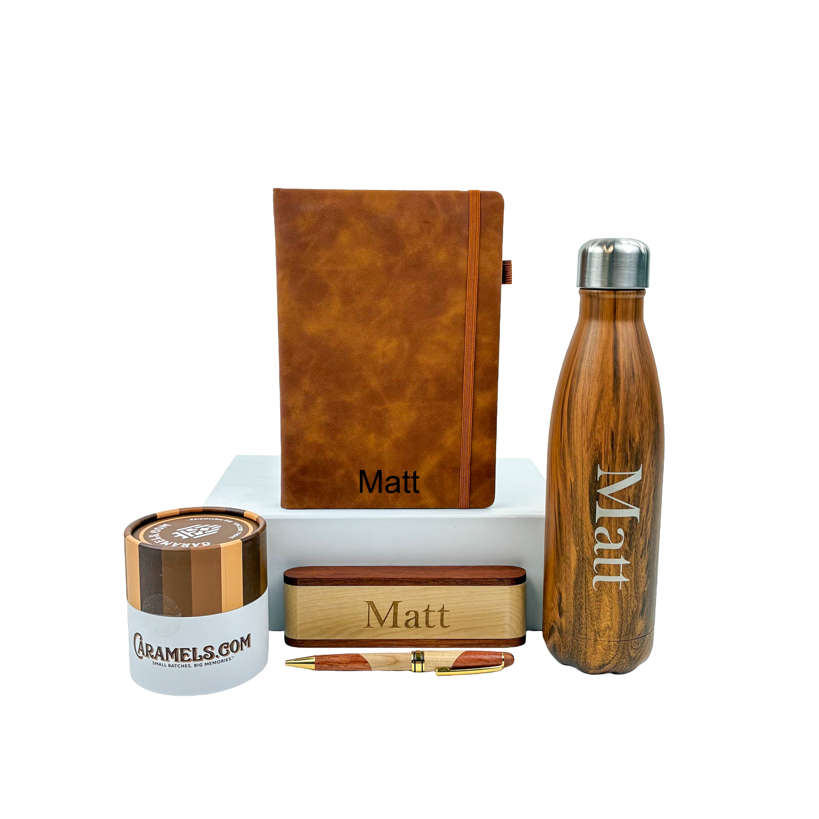Collection of personalized stationery items including a notebook, water bottle, and pen on a white background.