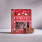 Red box of Rustic Bakery peppermint cookies on a white surface with a gray background