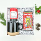 Gift set with a black mug, tea packaging, and candy cane packaging in a box.