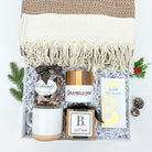 Gift basket with mug, chocolate, and hot chocolate mix on a white background