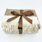 Blanket with brown ribbon and fringes on a white background