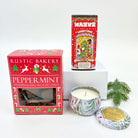 Holiday-themed products including a box of cookies, candy canes, and a candle on a white background