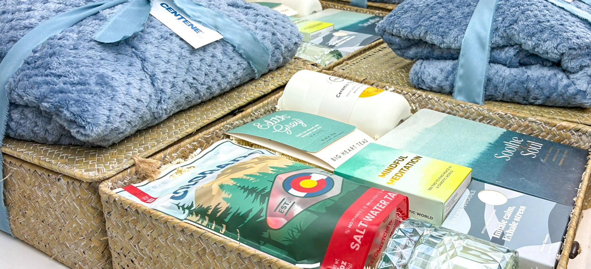 Collection of wellness gift baskets with blankets, candles, motivation items, and more. 
